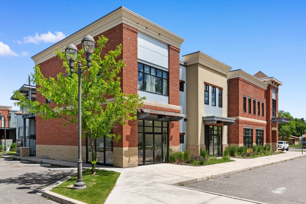 Modern multi-story building with brick, wood, and glass exterior
