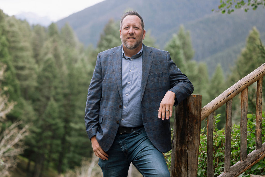 Brian Heck standing near a mountain property in Southwest Montana